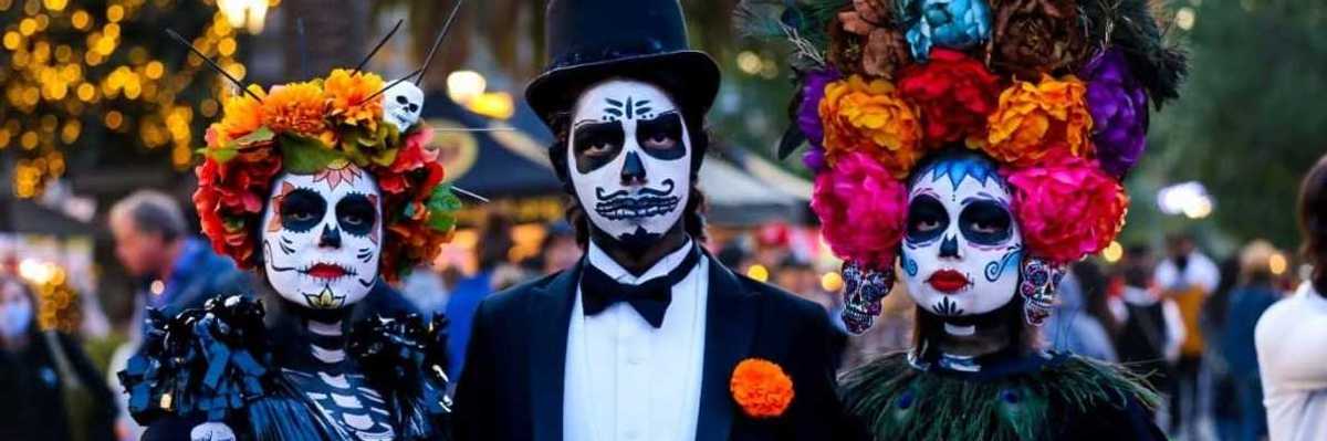 3 people dressed to the nines in dia de los muertos costumes