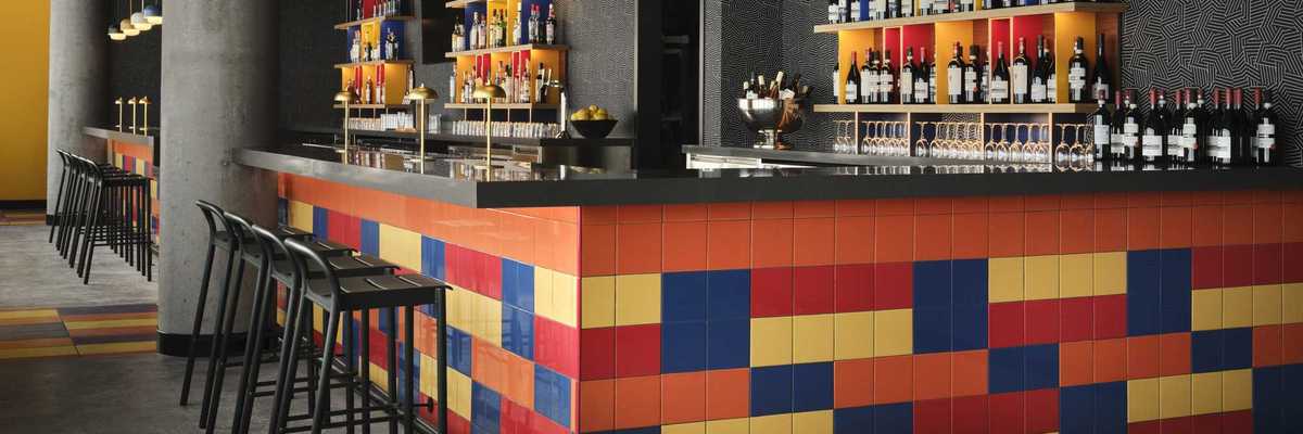 a bar with primary colored tile and grey walls