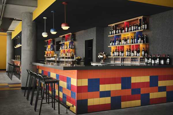 a bar with primary colored tile and grey walls
