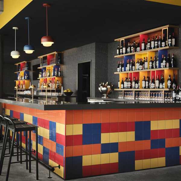a bar with primary colored tile and grey walls