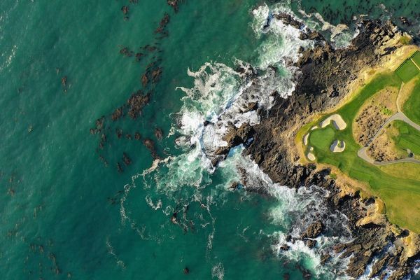 A bird's-eye view of a golf course along the rugged Pacific coast.
