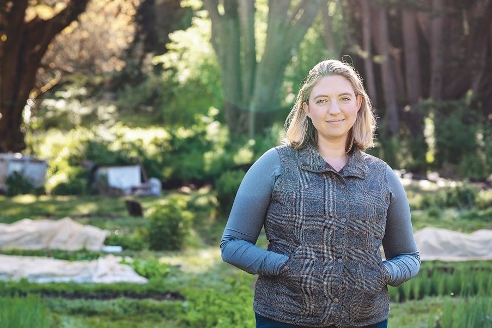 A blonde woman standing in a garden