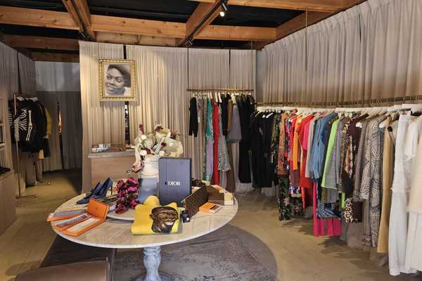 a boutique shop with clothes racks around the edges and a table with accessories in the middle