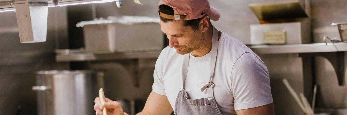 A chef with a butter brush and pate in his hand