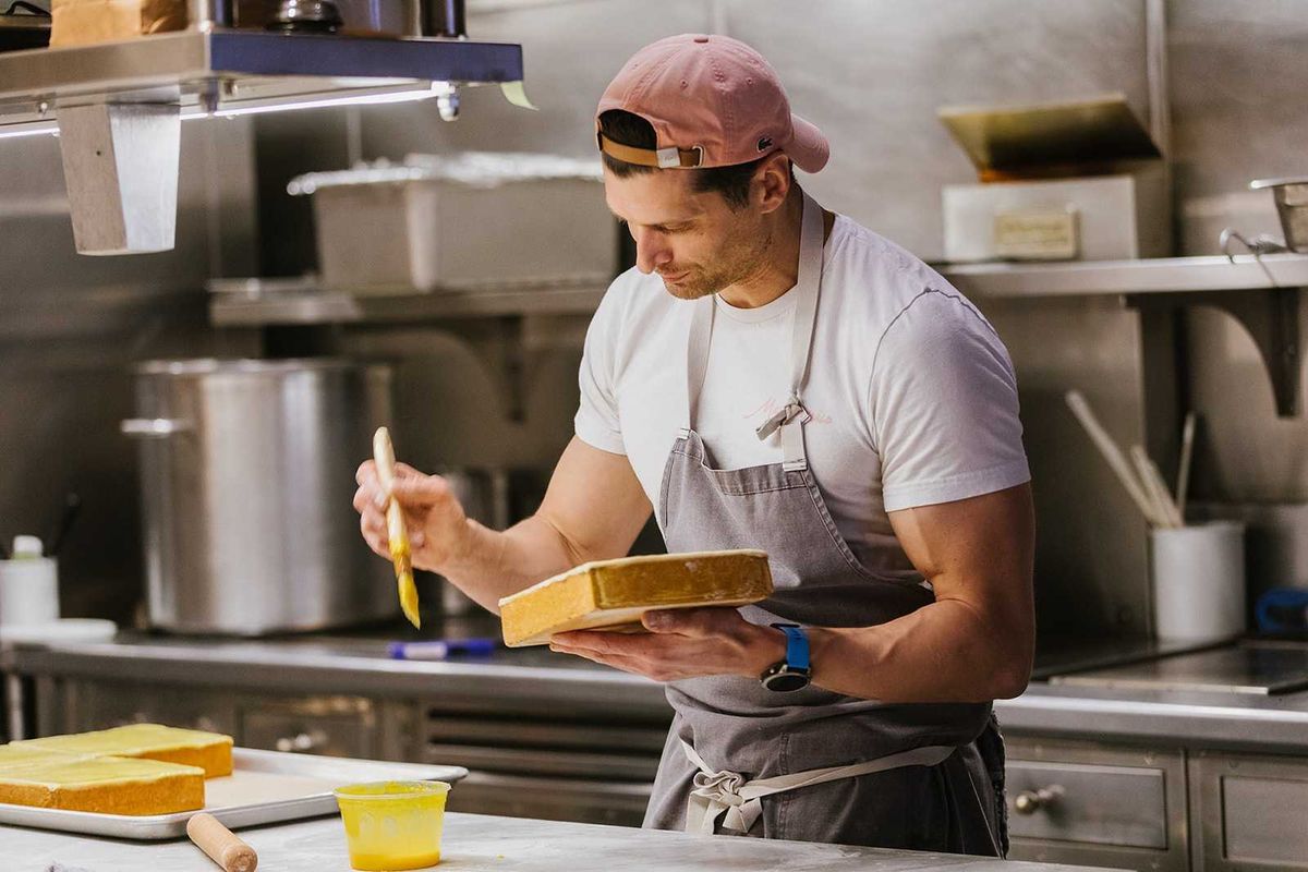 A chef with a butter brush and pate in his hand