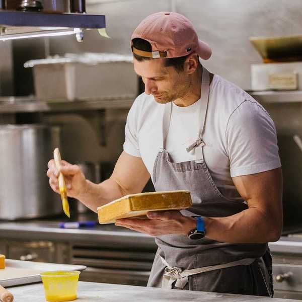 A chef with a butter brush and pate in his hand
