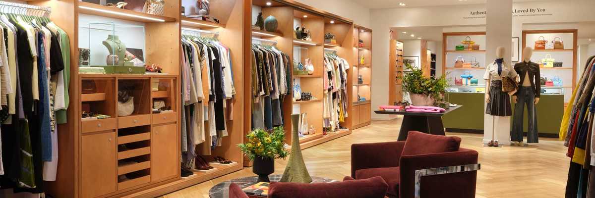 a clothing store with wooden built in closets and burgandy seating