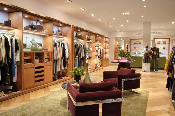 a clothing store with wooden built in closets and burgandy seating