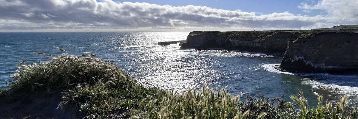a coastal scene with high cliffs and greenery