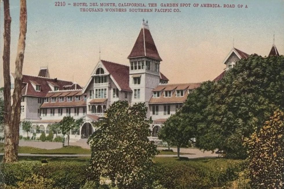 A colorized postcard of a hotel surrounded by greenery