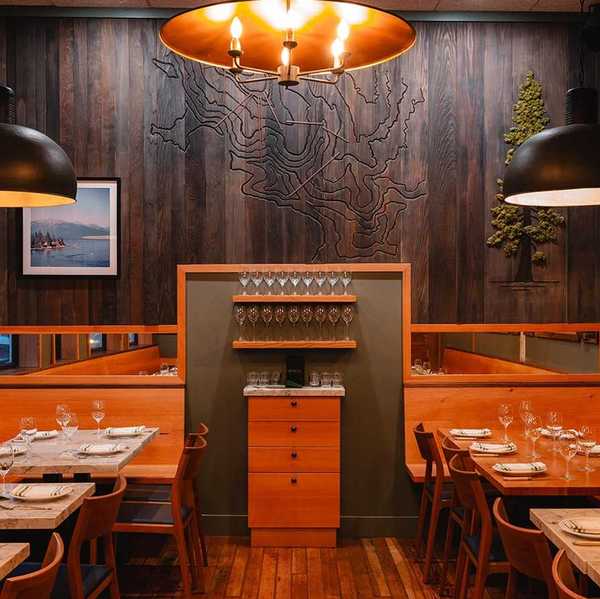a cozy restaurant with wood paneling and tables against the walls