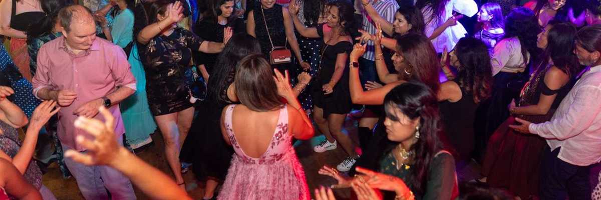 a crowd of people dancing at a wedding-style party