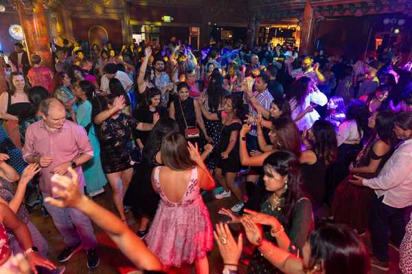 a crowd of people dancing at a wedding-style party