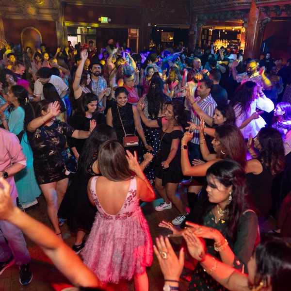 a crowd of people dancing at a wedding-style party
