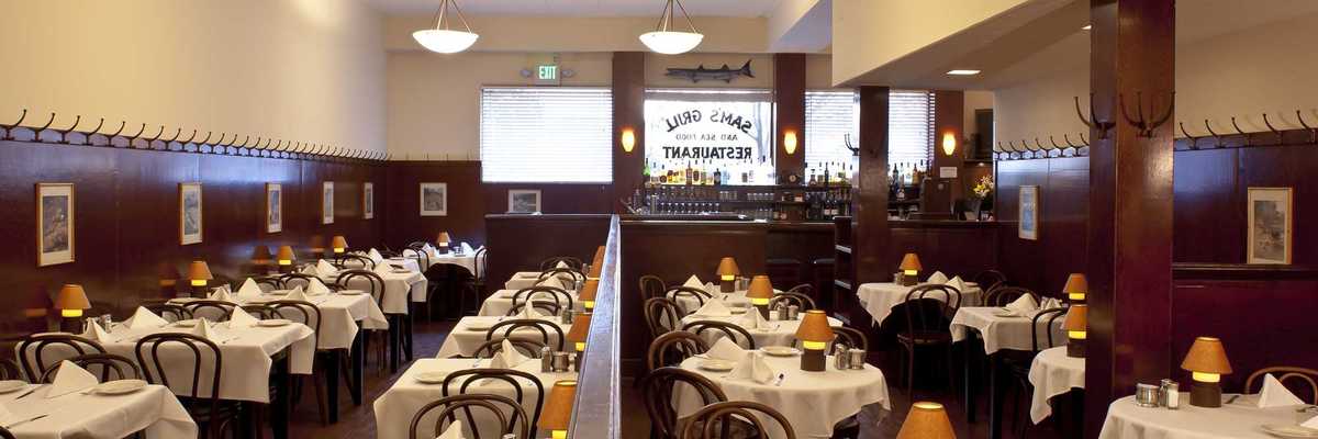 a dining room with tables with white tablecloths and small lights