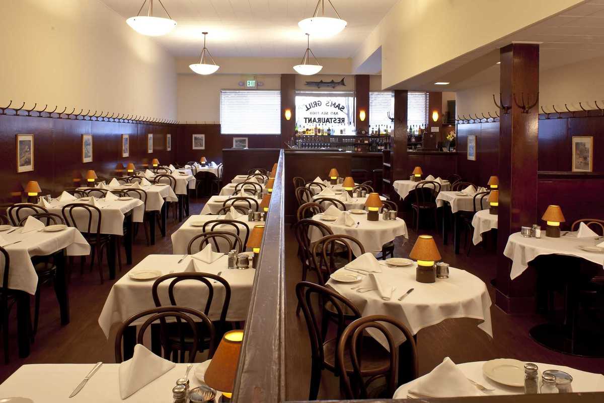 a dining room with tables with white tablecloths and small lights