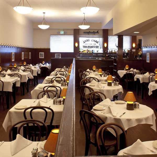a dining room with tables with white tablecloths and small lights