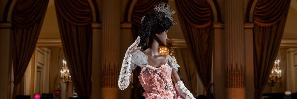 a dress made out of flowers on a mannequin in a grand salon