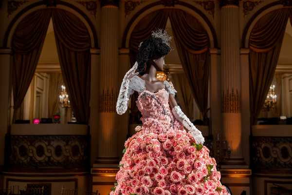 a dress made out of flowers on a mannequin in a grand salon