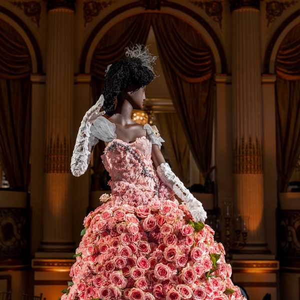 a dress made out of flowers on a mannequin in a grand salon