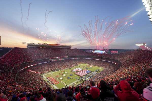 a football arena with stands full of fans and fireworks in the sky
