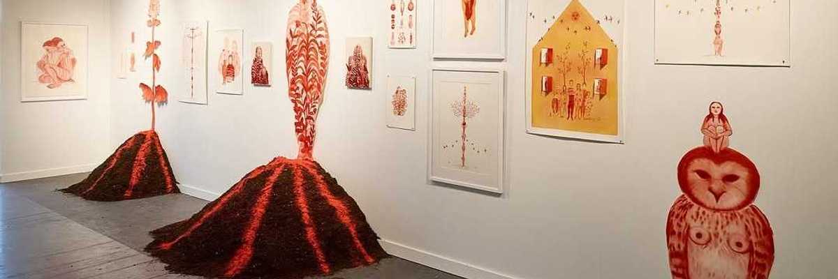a gallery with red watercolor art works on the walls and volcanoes