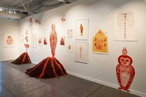 a gallery with red watercolor art works on the walls and volcanoes