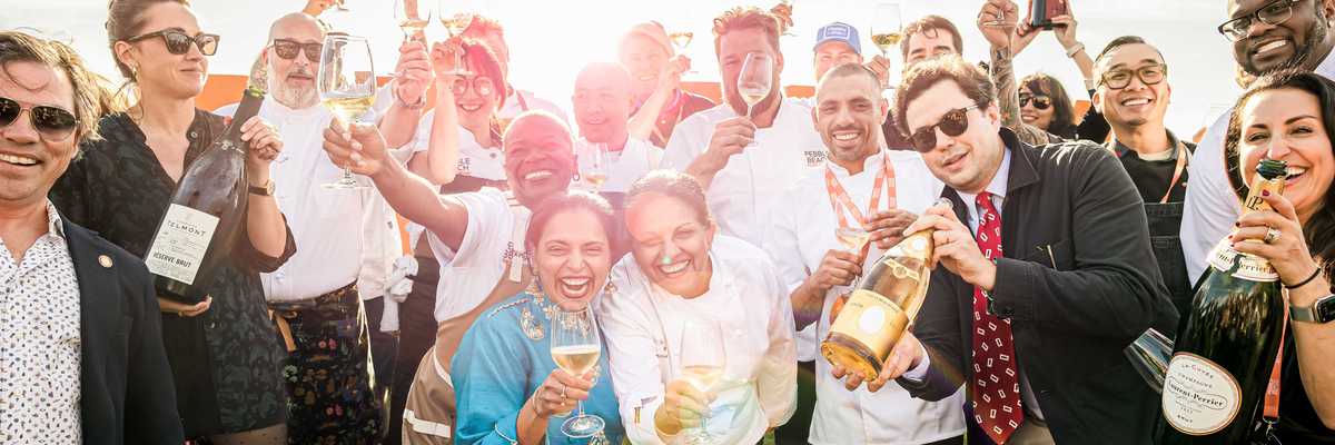 a group of chefs and others toasting with champagne