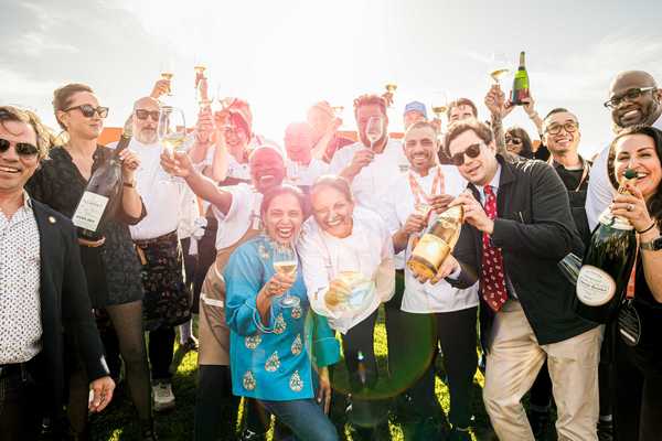 a group of chefs and others toasting with champagne