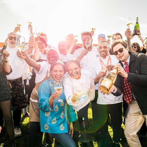 a group of chefs and others toasting with champagne