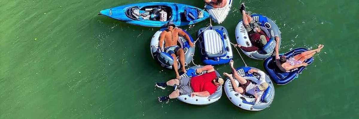 a group of inflatable rafts with people in them on a river float trip