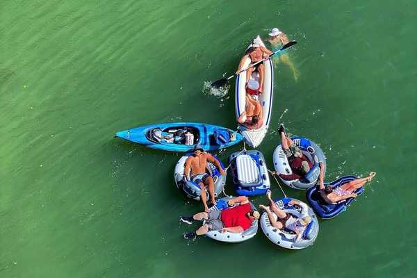 a group of inflatable rafts with people in them on a river float trip