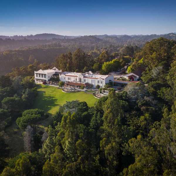 a hacienda-like hotel on a hill surrounded by forest