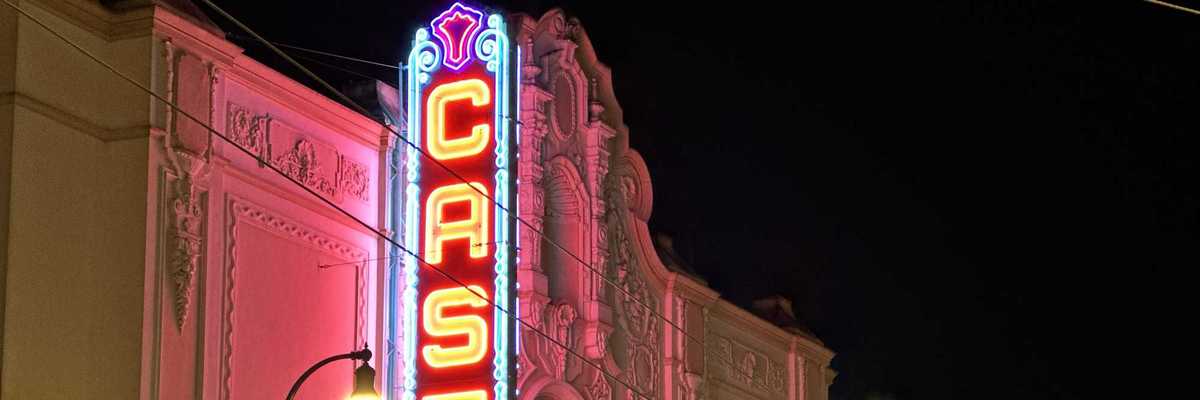 a historic movie theater with a glowing sign that reads Castro