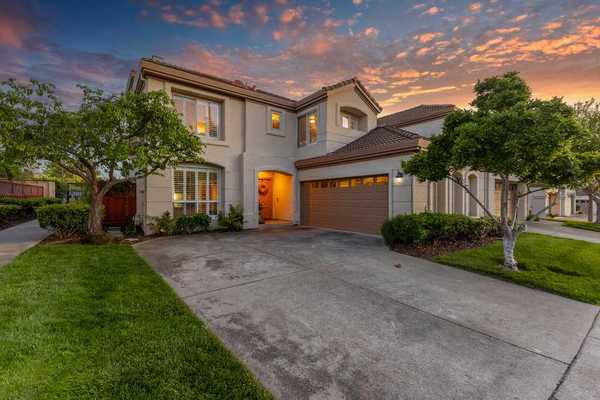 a large home with the sunset behind