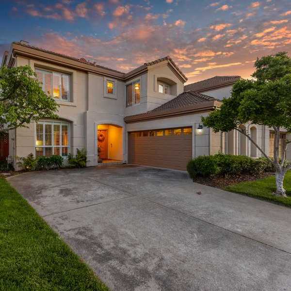 a large home with the sunset behind
