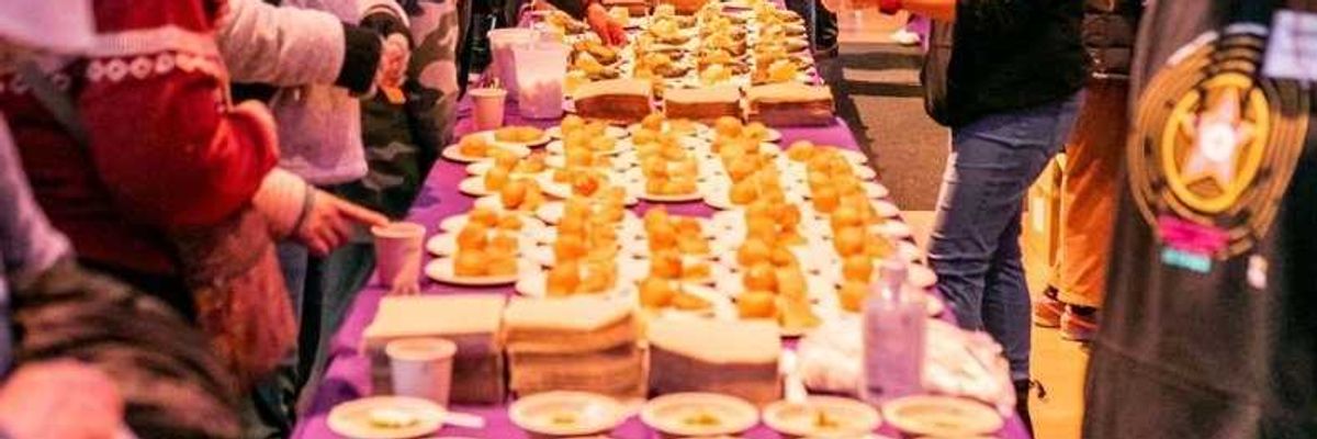 a long table with a purple tablecloth and sweet laid out down the entire length