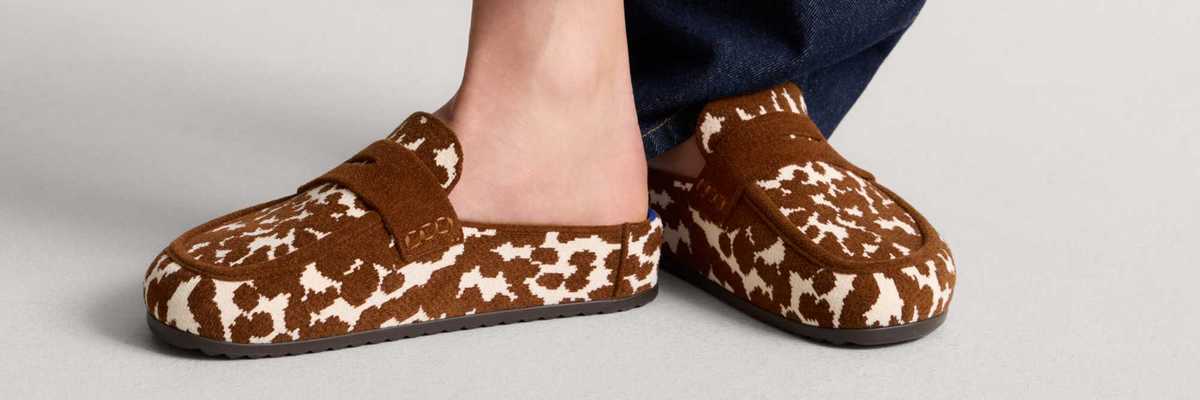 a pair of cow print velvety half loafer-half clog shoes
