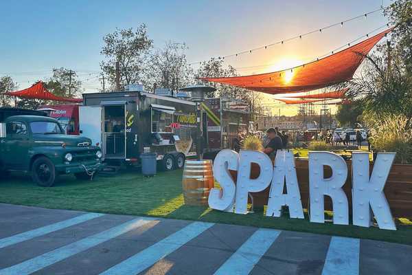 a park with the words SPARK in front and food trucks set up