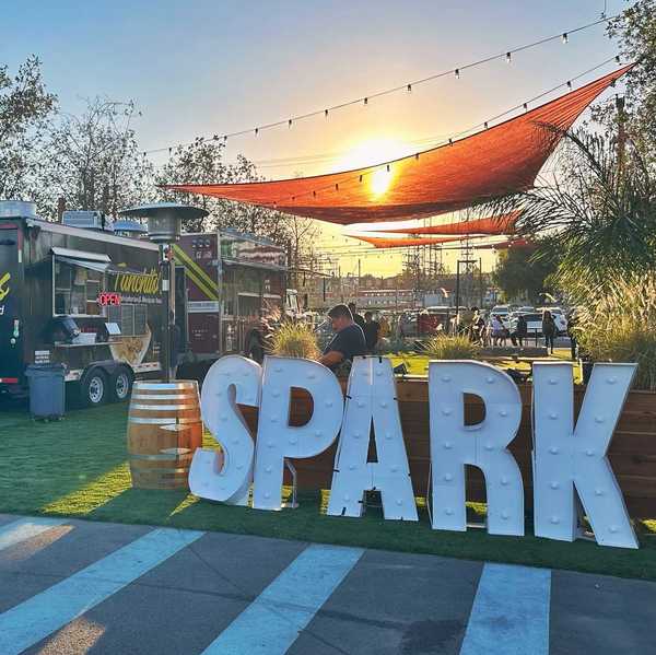 a park with the words SPARK in front and food trucks set up