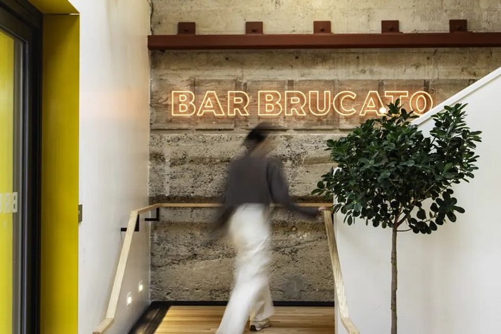 A person walks up the stairs of a bar lobby.