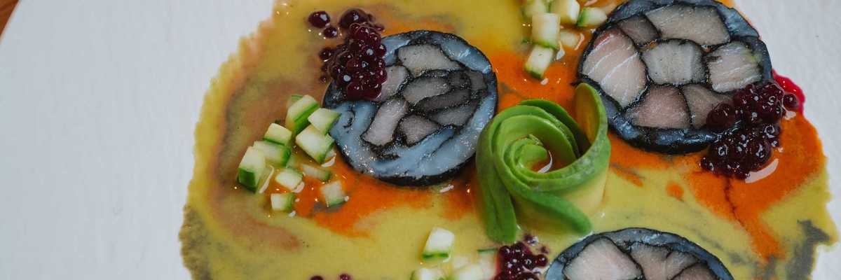 a plate with raw fish aguachile in a citrus marinade with cucumbers and avocado