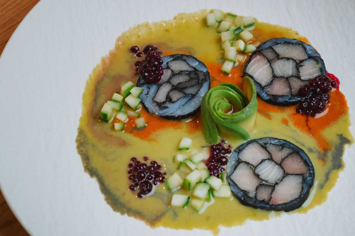 a plate with raw fish aguachile in a citrus marinade with cucumbers and avocado