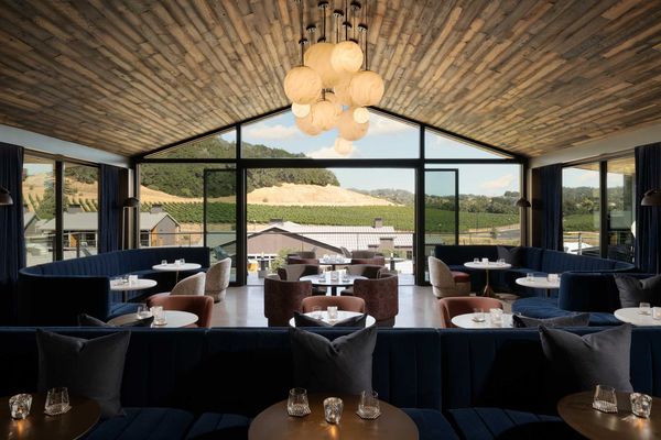 a rooftop dining area with a view of vineyards and a wood ceiling