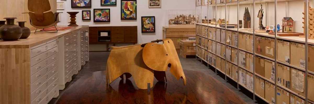 a room of ephemera with shelves of toys on the right wall and an elephant in the center