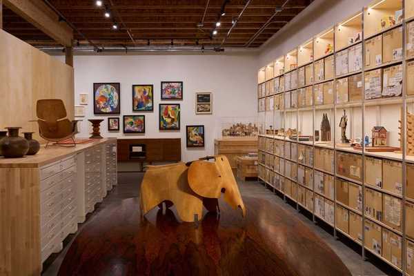 a room of ephemera with shelves of toys on the right wall and an elephant in the center