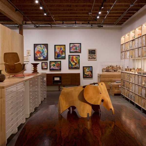 a room of ephemera with shelves of toys on the right wall and an elephant in the center