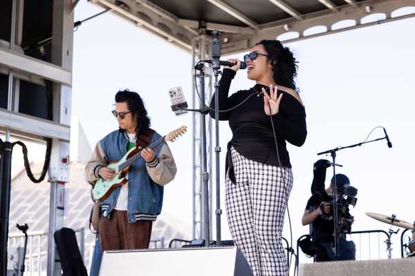 a singer and guitar player on a stage
