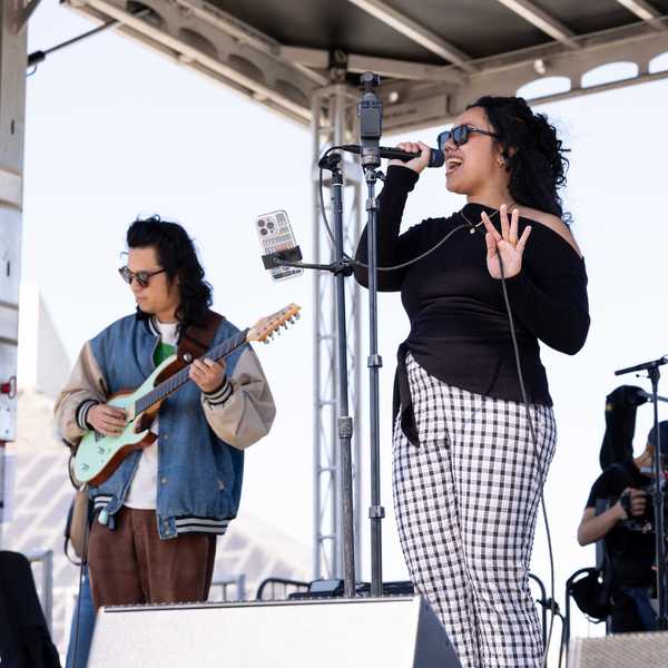 a singer and guitar player on a stage
