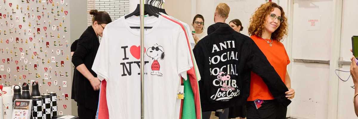 a Snoopy-themed shop with a woman holding up a Snoopy jacket and other shoppers around
